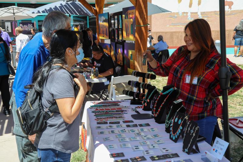 A vendor sells jewelry to visitors at the Spring Arts Market at the Indian Pueblo Cultural Center